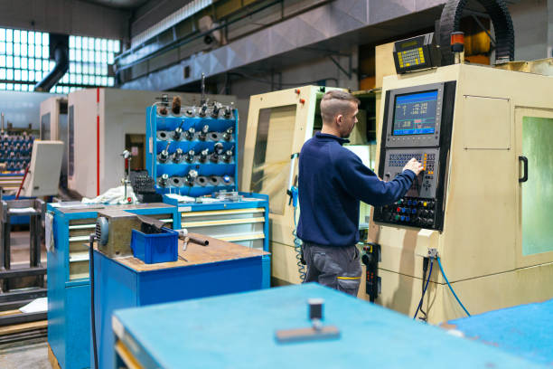 A skilled operator controls a CNC machine in an industrial environment, meticulously shaping metal parts.